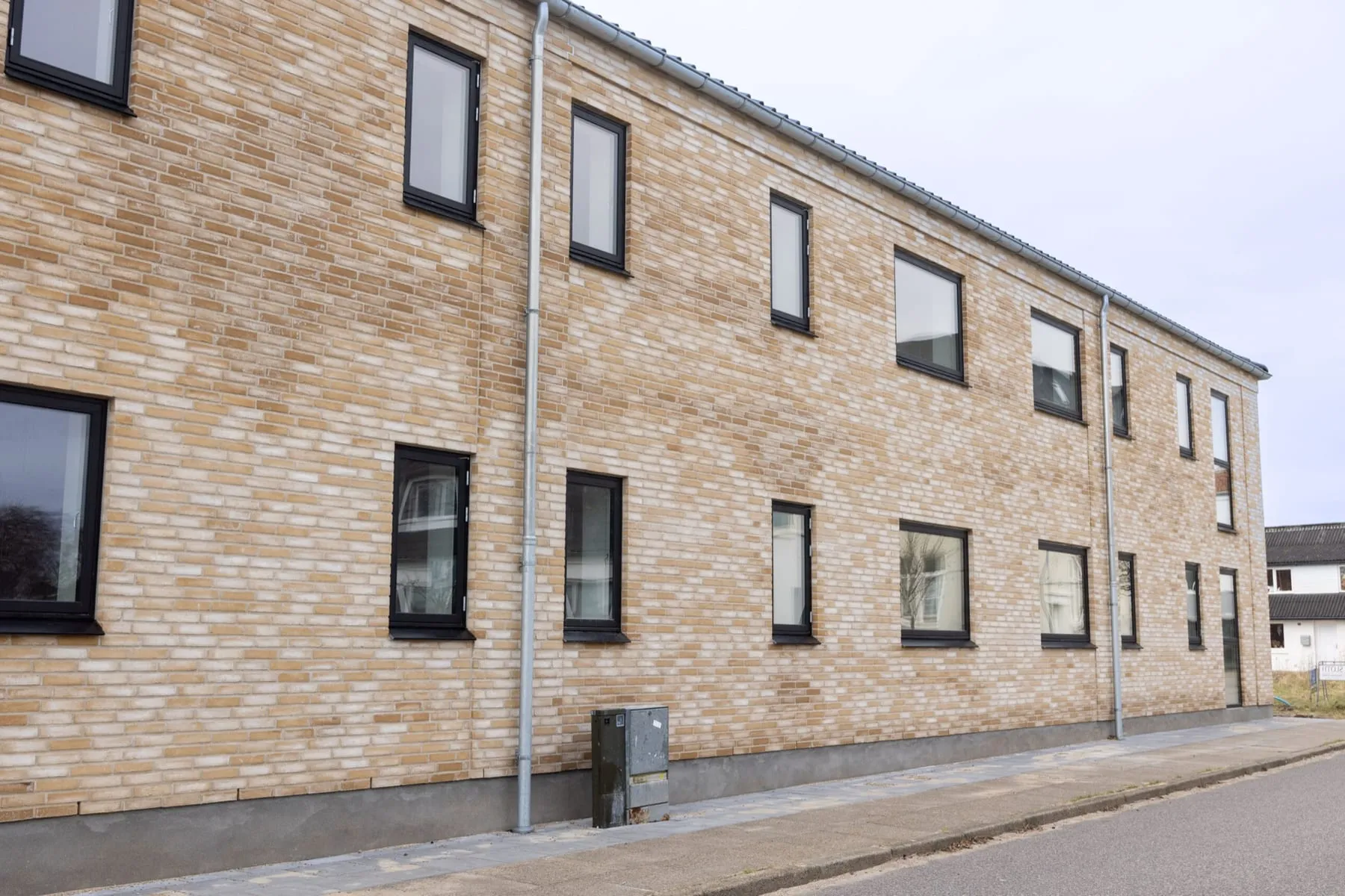 Moderne murstensbygning med sorte vinduespartier